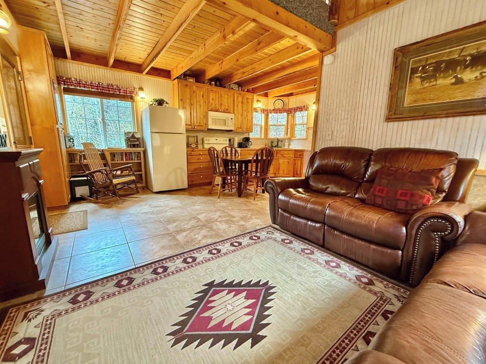 Cozy open-concept cabin living with comfortable seating and a fully-equipped kitchen at HappyOur Ranch.