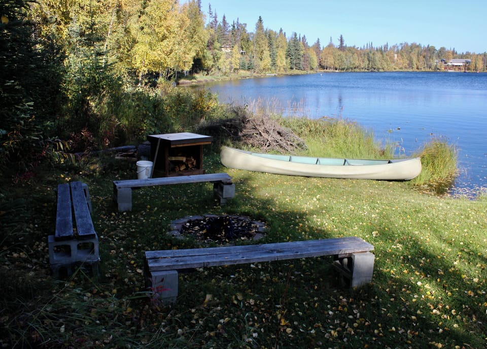 Large aluminum canoe and fire pit with benches