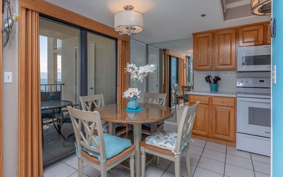 Bright dining area with a round table, stylish chairs, and a lovely view through sliding glass doors