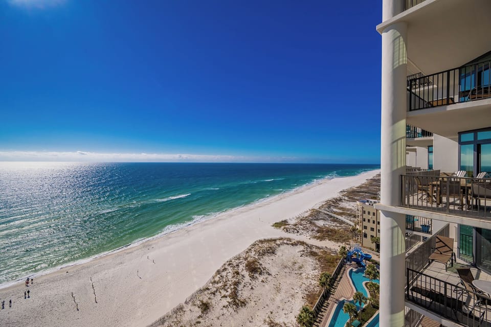 Enjoy stunning beachfront views from the balcony, with a view of the pool and lazy river area and lush palm trees below