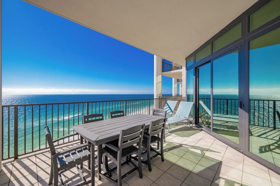 This twelfth-floor balcony features a dining table with seating, perfect for enjoying beach views and relaxing in the sun