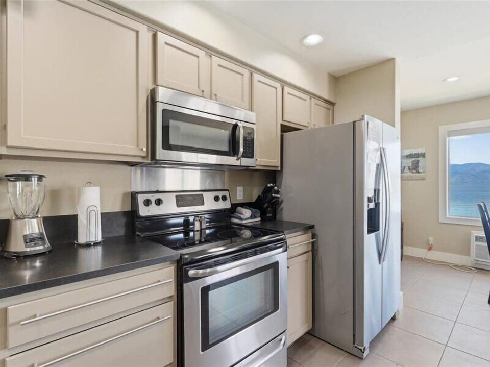 Your fully equipped kitchen features stainless steel appliances, ample counter space, and everything you need to prepare meals while enjoying stunning lake views through the window.