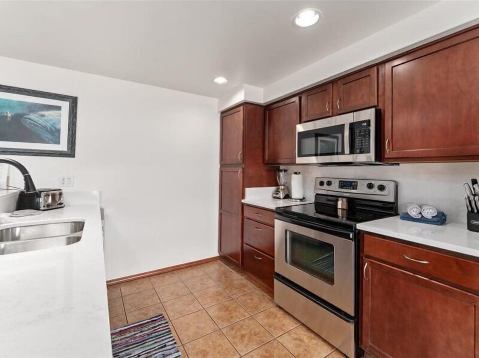 Your fully equipped kitchen awaits with gleaming stainless steel appliances, rich cherry cabinets, and everything you need to create memorable meals.