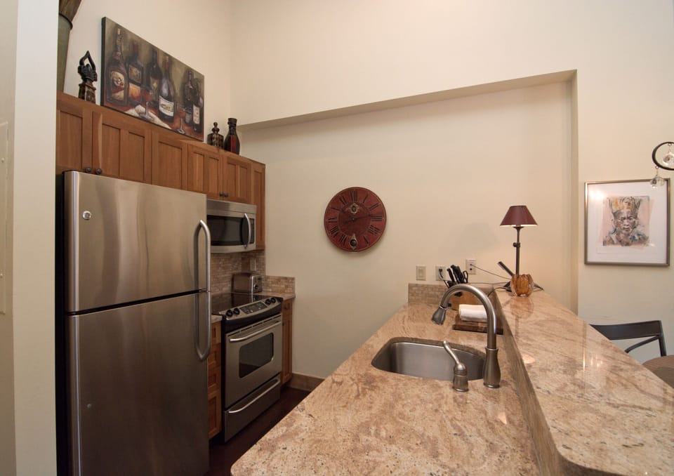 The fully equipped kitchen has granite counters and stainless appliances.