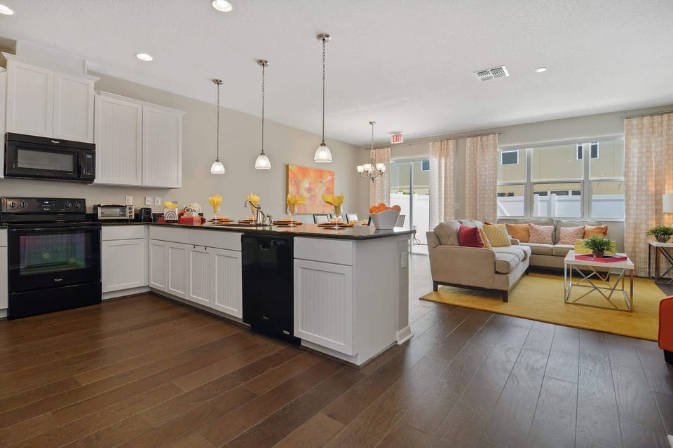 Sunny open-plan living-cook in the modern kitchen with island seating, then unwind in the cozy lounge with cheerful pops of orange and yellow.