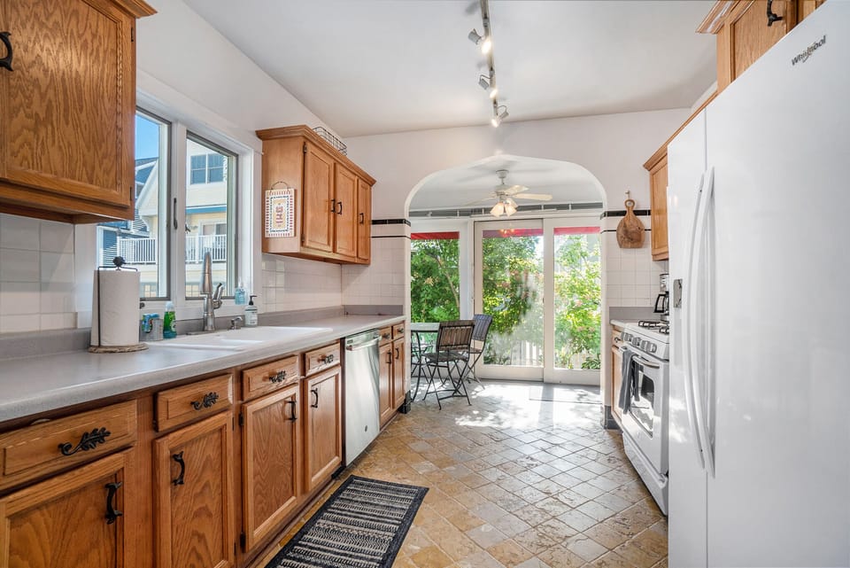 Kitchen with dishwasher, gas range, microwave, refrigerator with ice maker.