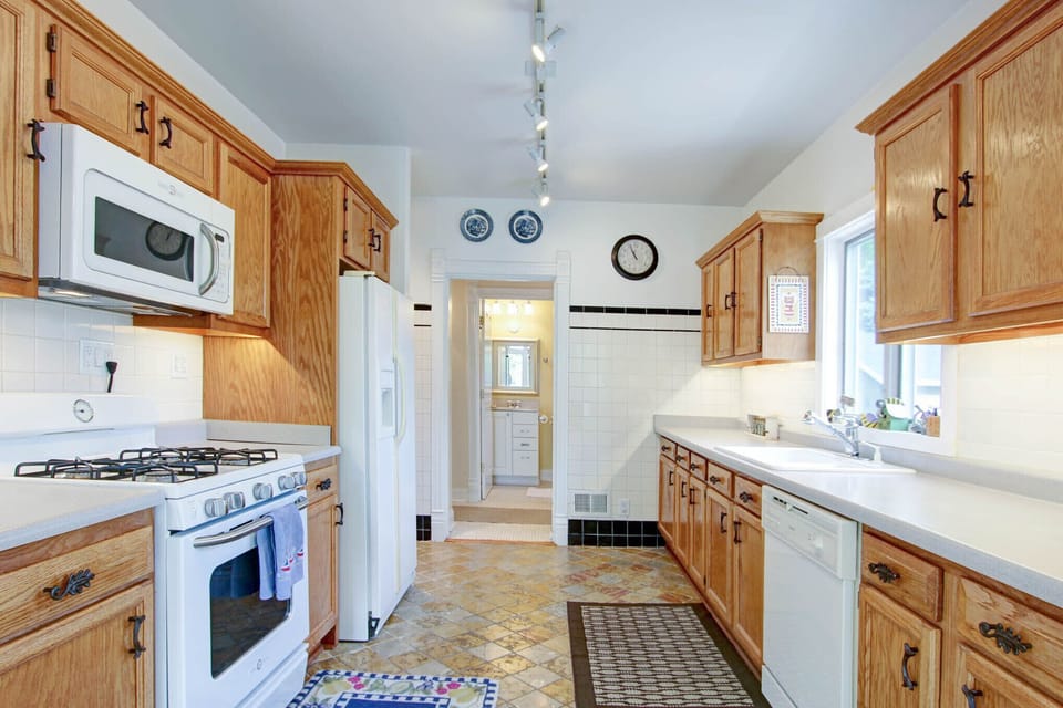 Kitchen with dishwasher, gas range, microwave, refrigerator with ice maker.