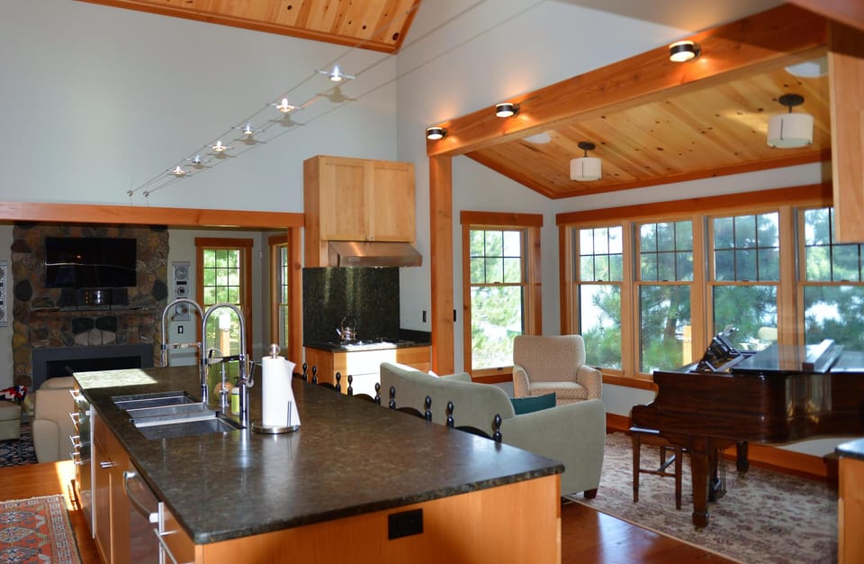 Kitchen/Living/Dining and piano all view the lake, docking, and swimming areas.