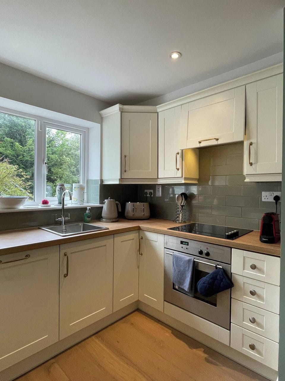 Kitchen with oven, hob, microwave, dishwasher, kettle, toaster & coffee machine.