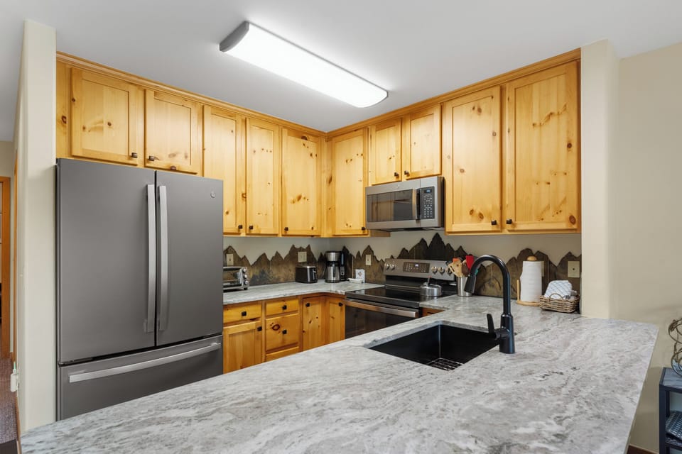 Whip up your favorite meals in this fully-equipped kitchen with granite counters, stainless steel appliances, and charming pine cabinetry.