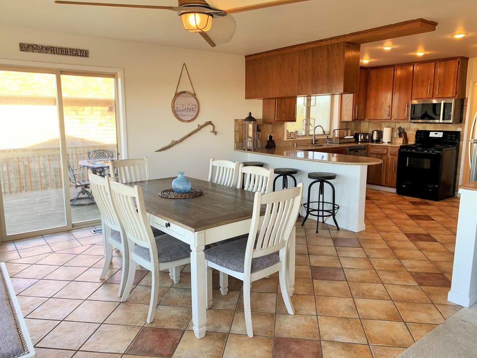 Kitchen and dinning room with sliding glass door out to deck and patio seating