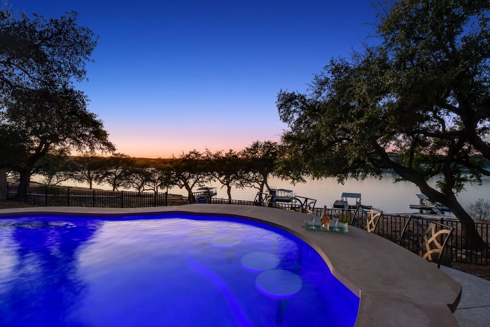 Swim-up bar seating overlooking Lake Travis at sunset