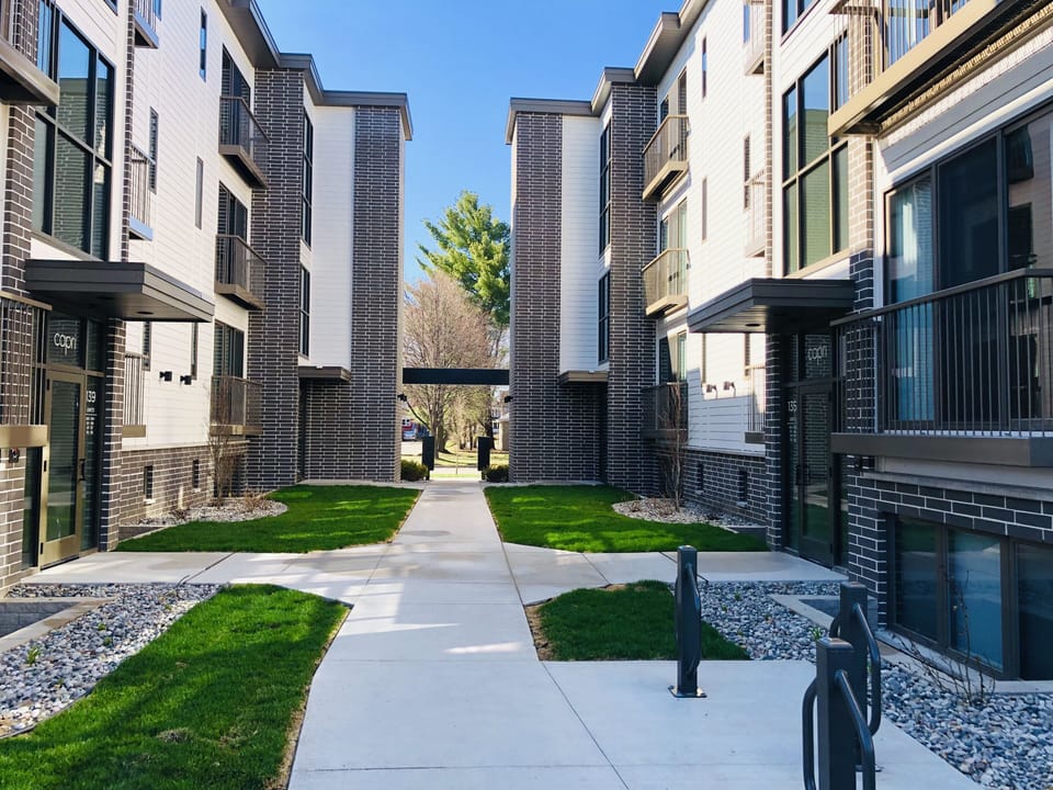 View from parking lot. Small courtyard. Bike Racks 