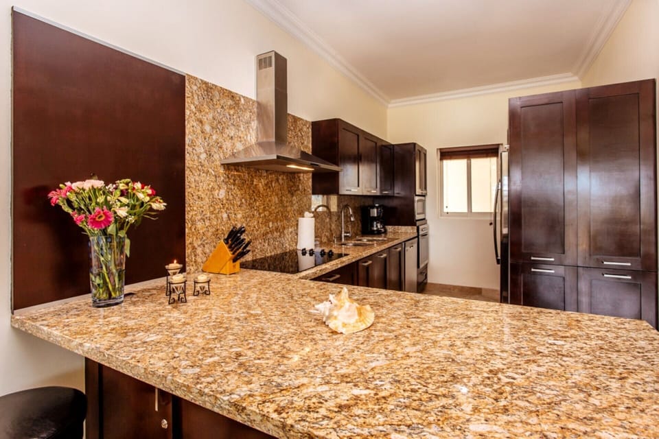 Fully-equipped modern kitchen has oven, microwave, 5 burner cooktop, dishwasher