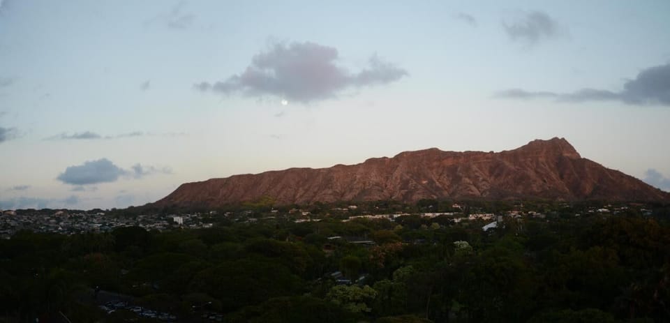 Up on the roof deck, as the sun sets a full moon rising over Diamond Head.