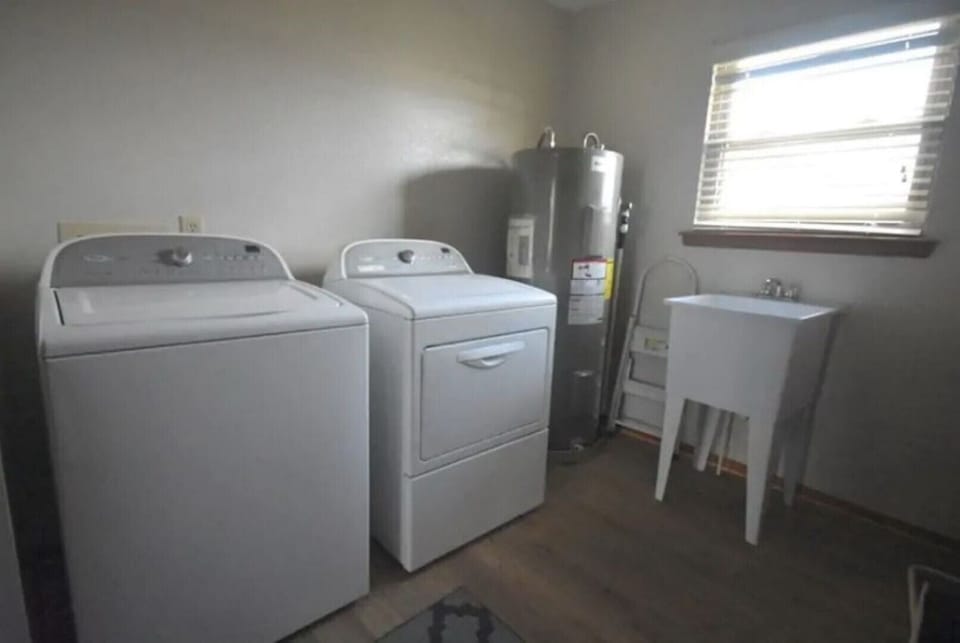 Utility room-full sized washer and dryer with 50 gal. water heater, and basin.