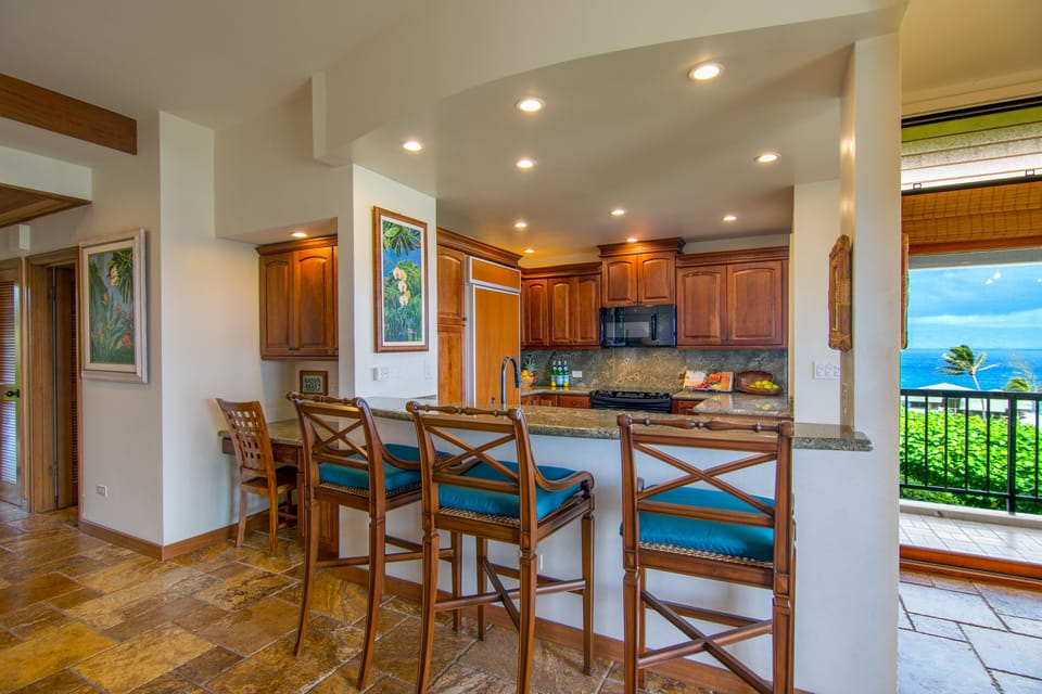 The view of the kitchen and bar stools from the living room.