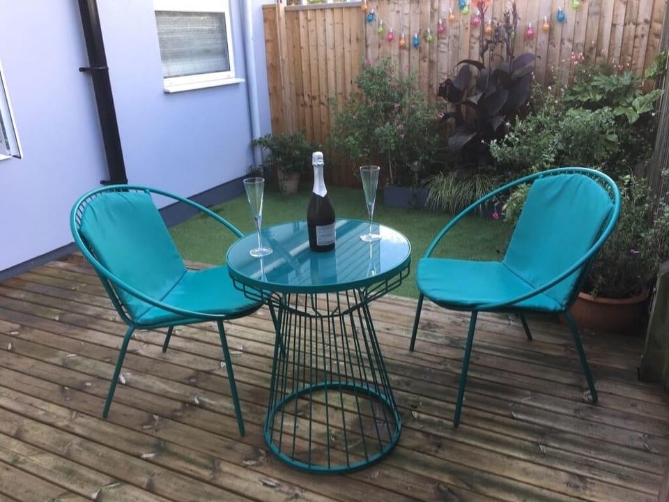 Raised decking with table and chairs. Artificial Grass on Garden. Enclosed
