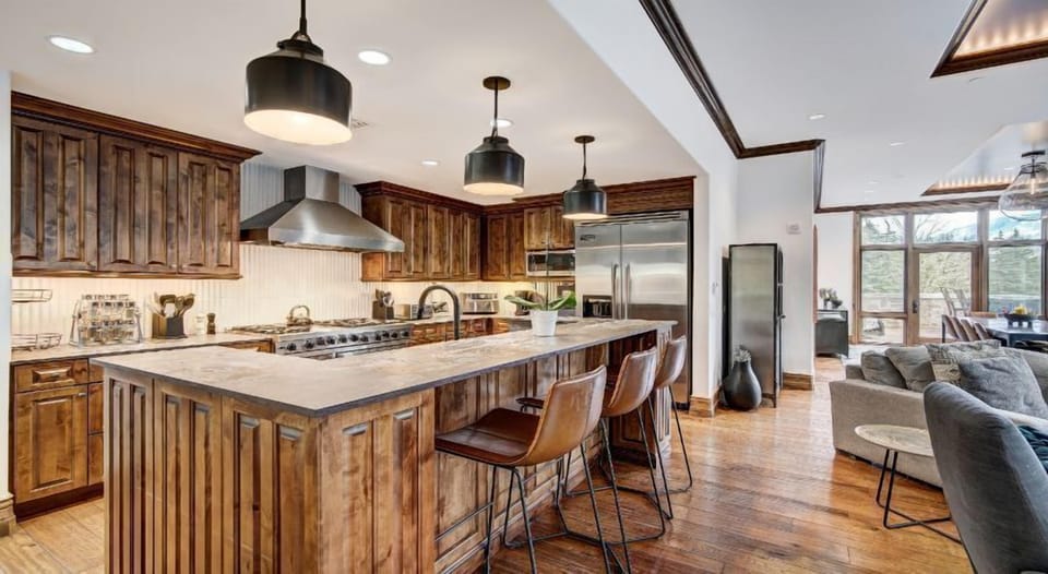 The gourmet kitchen is a chef's dream, featuring rich wood cabinetry, top-of-the-line appliances, and a welcoming island bar for casual dining.