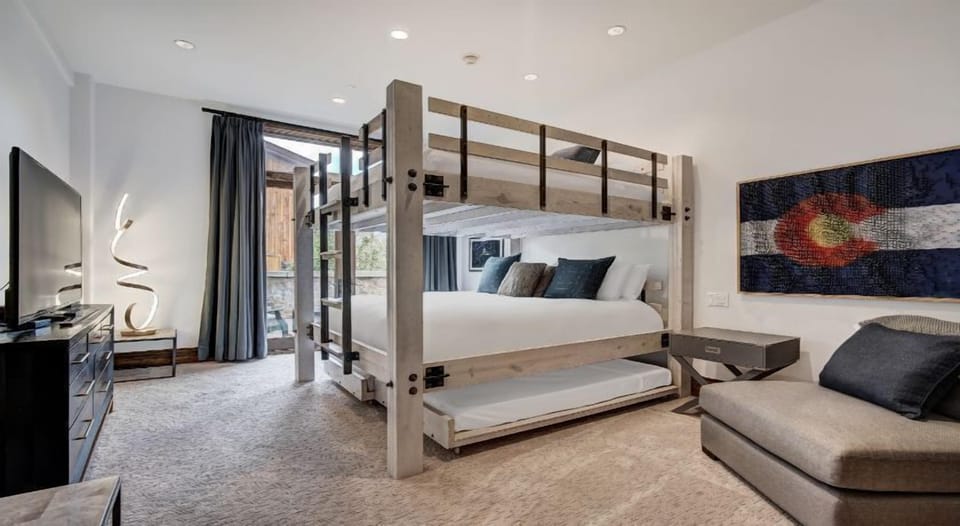 This sleek bedroom combines modern comfort with a touch of rustic charm, featuring a stylish bunk bed design and elegant textiles.