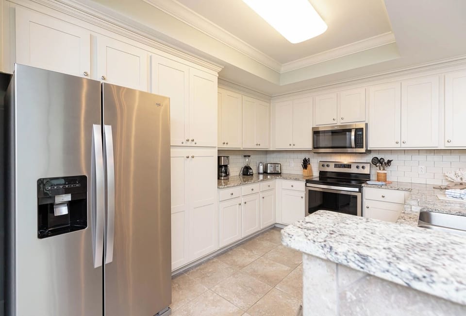 Prepare meals in this kitchen with elegant cabinetry, stainless appliances, and stylish backsplash