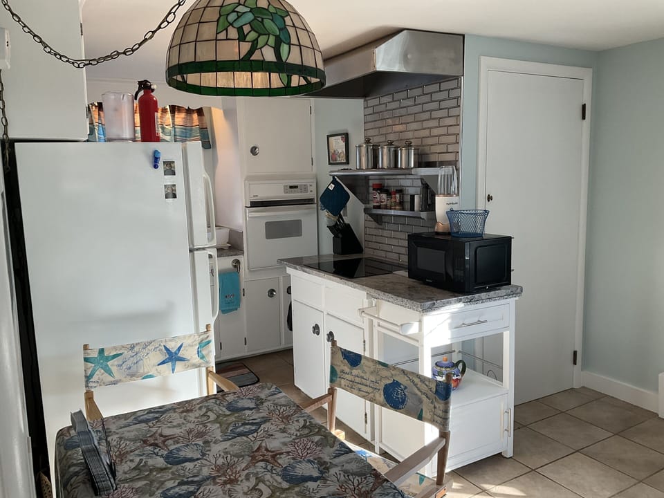 Small work in kitchen with granite countertops and stainless steel shelving.