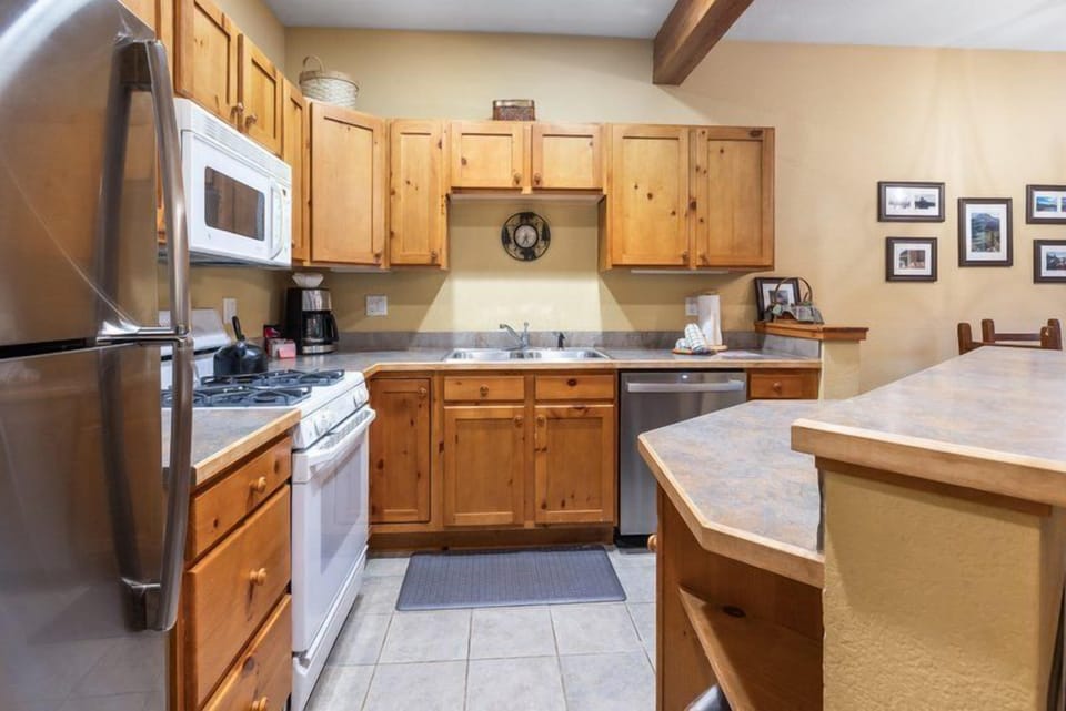 A warm, inviting kitchen featuring rich wooden cabinetry and modern appliances, perfect for home-cooked meals.