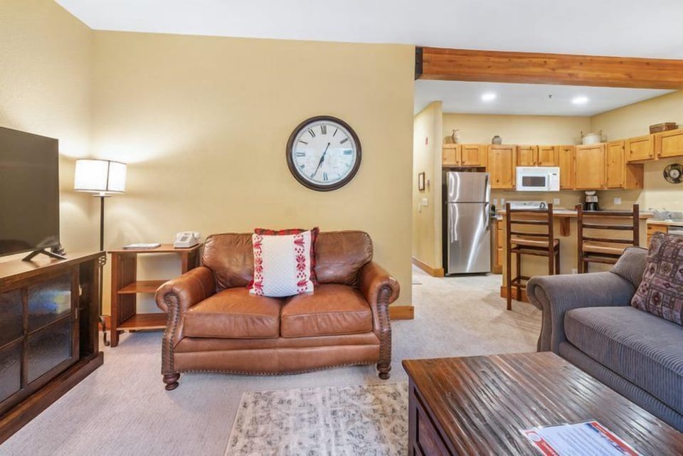 The cozy living area offers a stylish leather couch and a spacious layout, ideal for relaxation after a day of adventure.