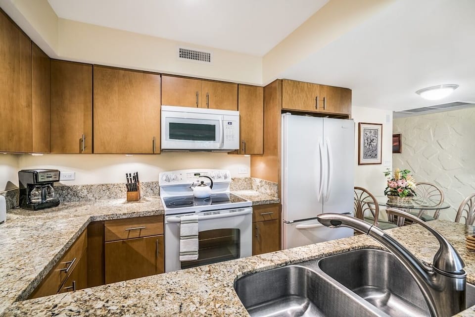 Kitchen with oven, fridge and sink.