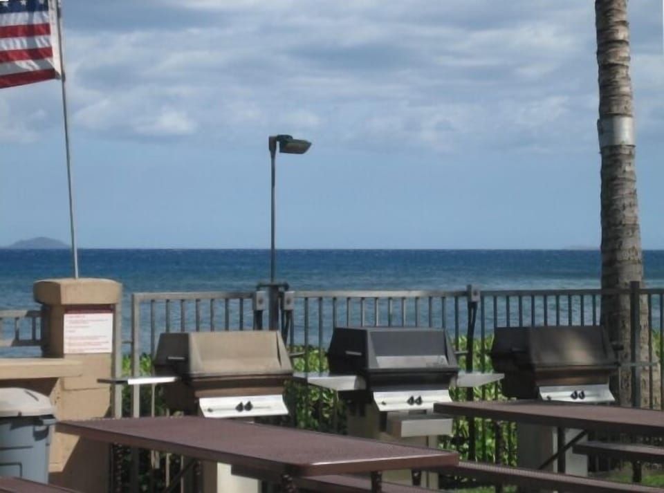 Barbeque area right on the ocean with picnic tables at the pool