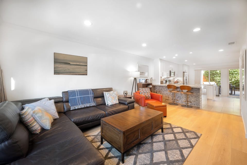 Light and bright living room with leather sectional sofa, coffee table and chair