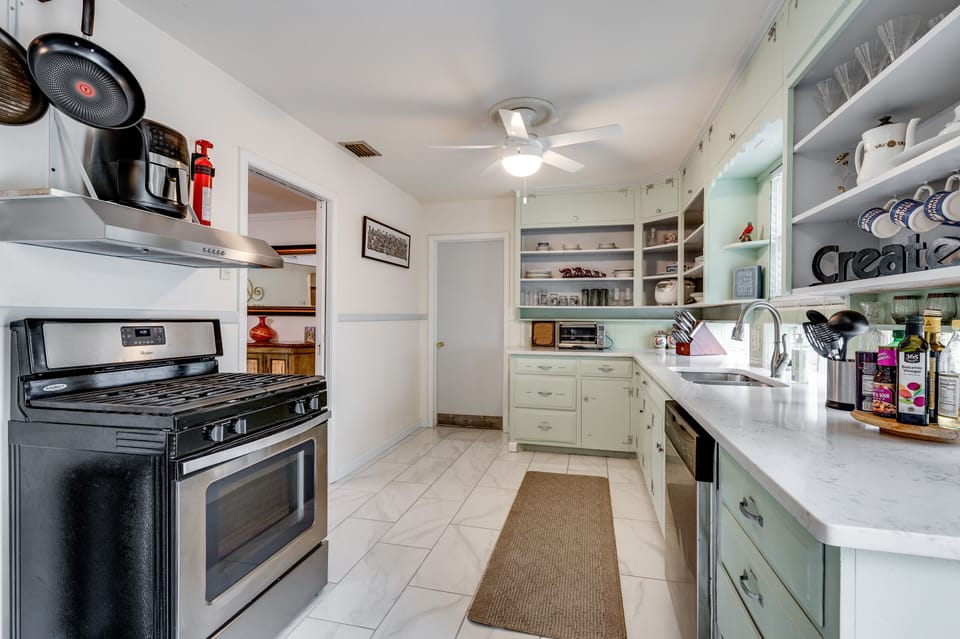 Quartz counter, stone floors, and gas cooktop.  

Well-stocked kitchen.