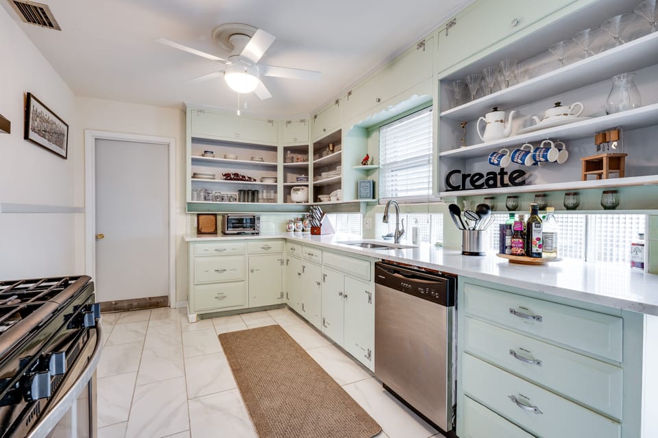 Quartz counter, stone floors, and gas cooktop.  

Well-stocked kitchen.