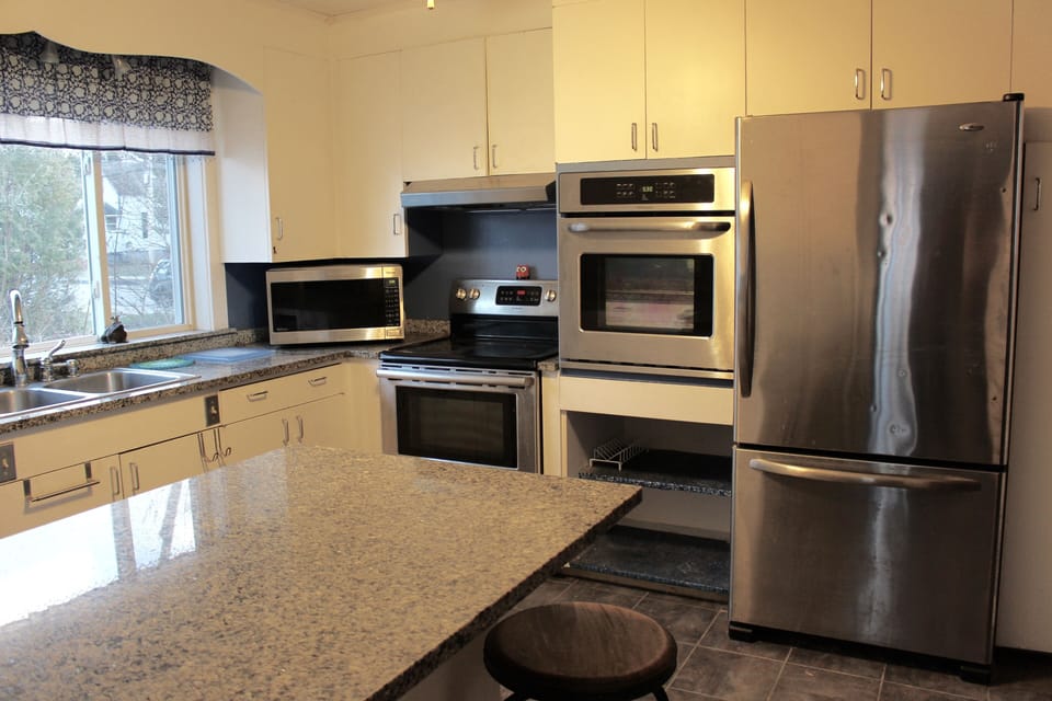 The kitchen is equipped with a second oven, microwave, coffee maker, and fridge. 