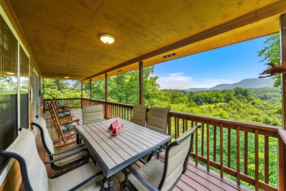 Back deck with picnic table, rocking chairs and swing and a peaceful view