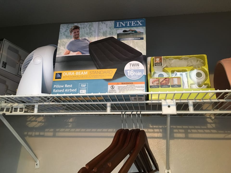 Two twin sized air mattresses, and a fan in closet