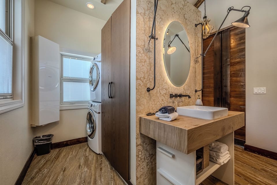 Convenient, glamorous, stylish laundry rm with washer, dryer, ironing board. 