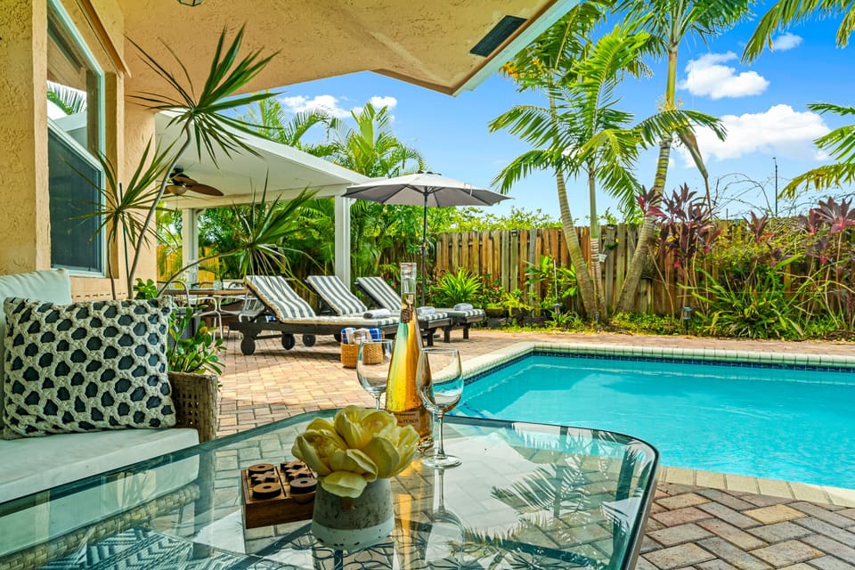 Conversation Set on covered patio with ceiling fan, tropical views, and pool.