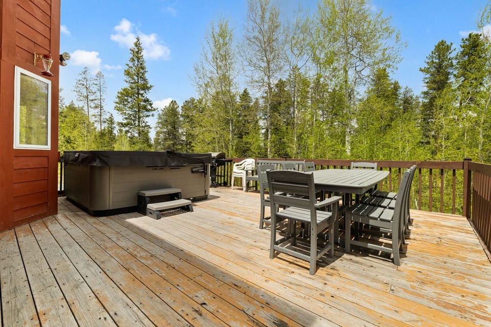 Deck with large hot tub and outdoor dining. 