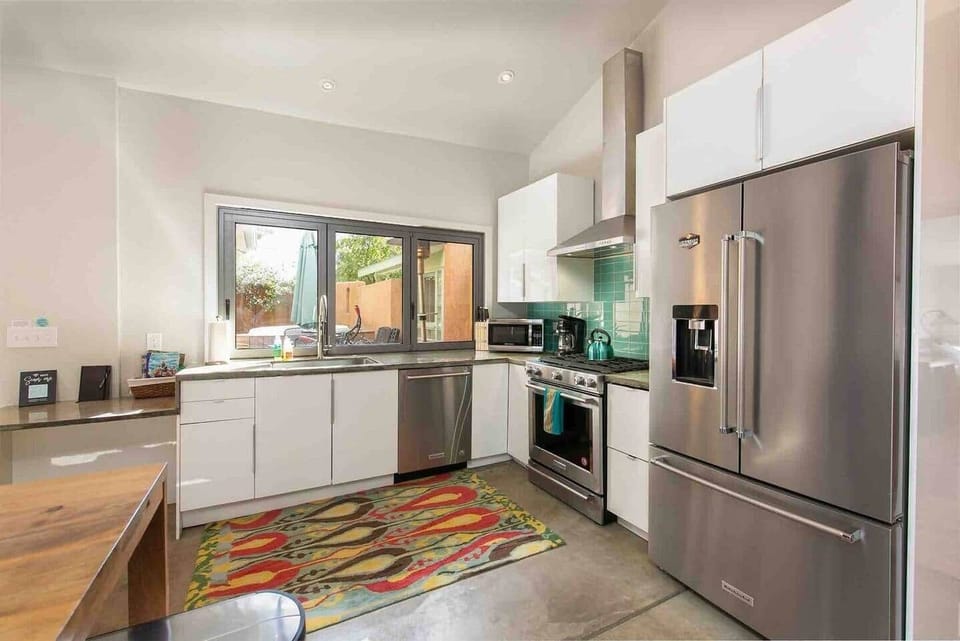 Bright modern kitchen with accordion window that opens to courtyard.