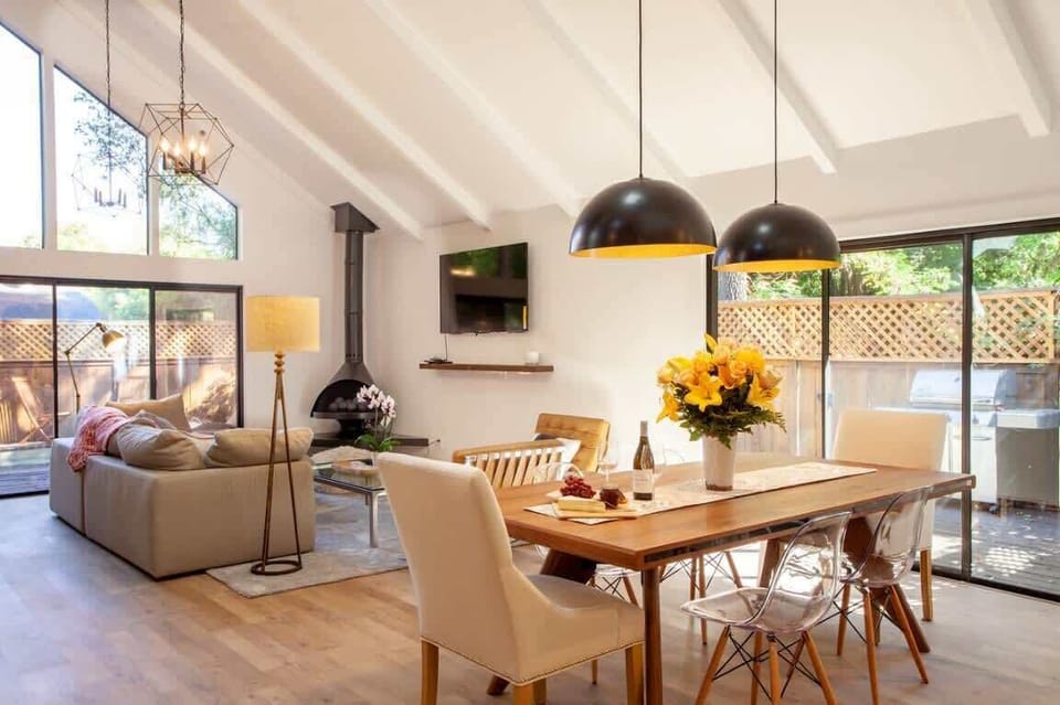 Bright, modern retreat with vaulted ceilings, chic lighting, and an open living–dining layout. Enjoy floor-to-ceiling windows, cozy fireplace, stylish furnishings, and seamless indoor-outdoor flow with a private deck and grill.