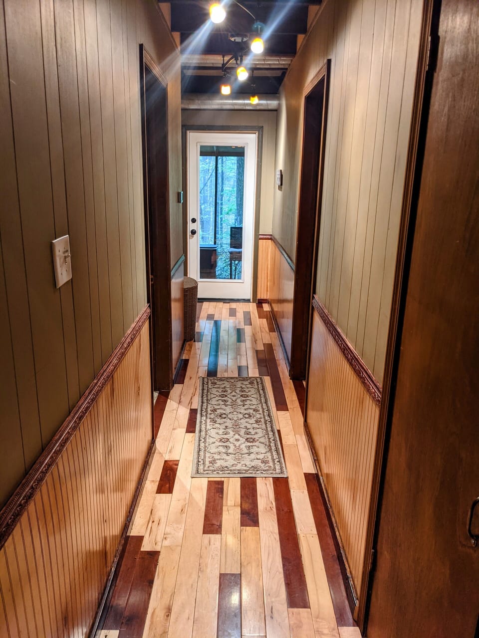 Downstairs hallway leading to back deck. Bathroom to right & bedroom to left