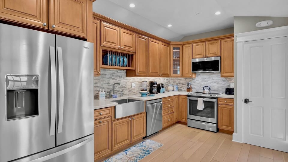 Your fully equipped kitchen welcomes you with stainless steel appliances, warm wood cabinetry, and bright recessed lighting...