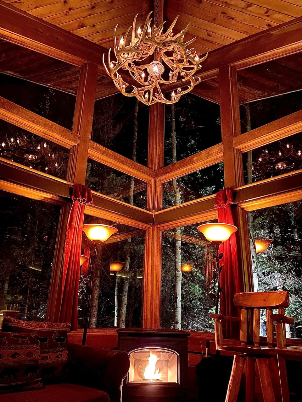 Nighttime at the cabin...the lights 💡 bring it/the forest alive!  20’ ceilings!