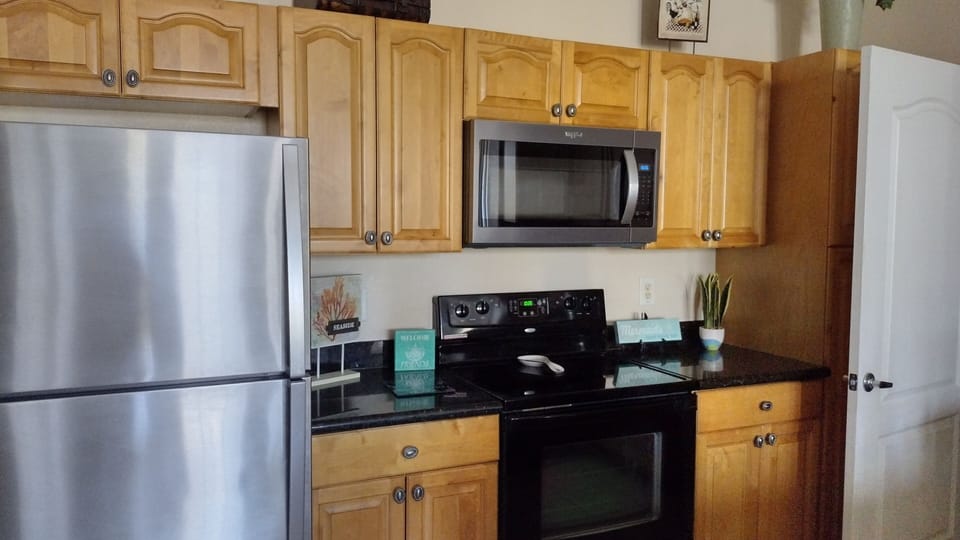 Kitchen with new refrigerator and microwave.