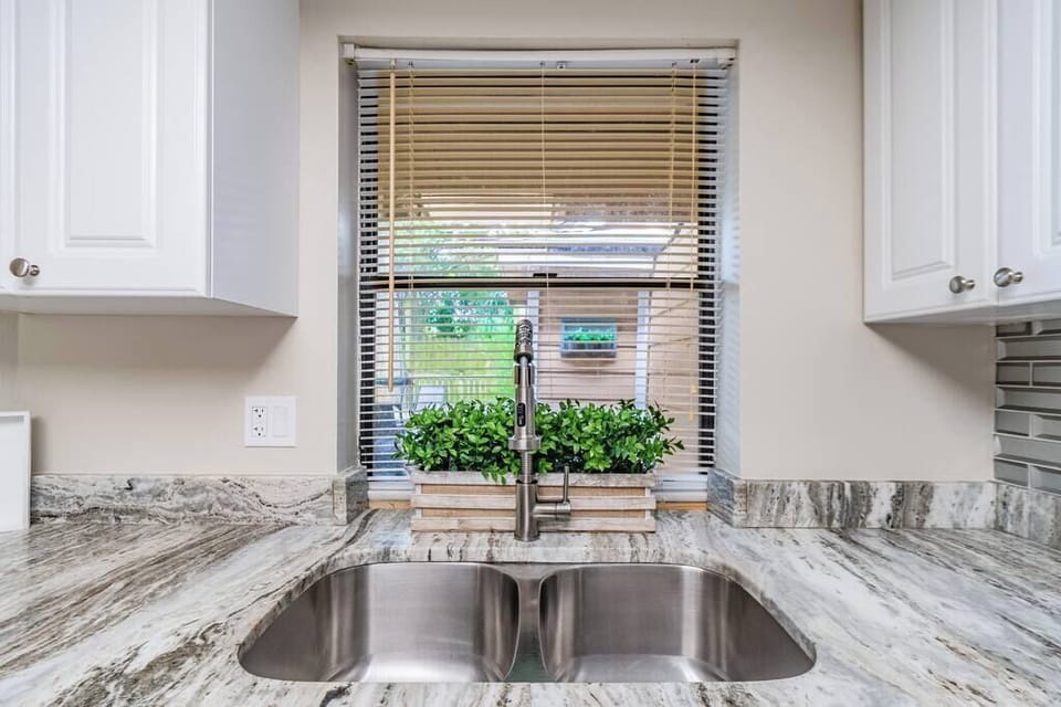 Double stainless steel sink with garbage disposal with a view to the outdoor living space