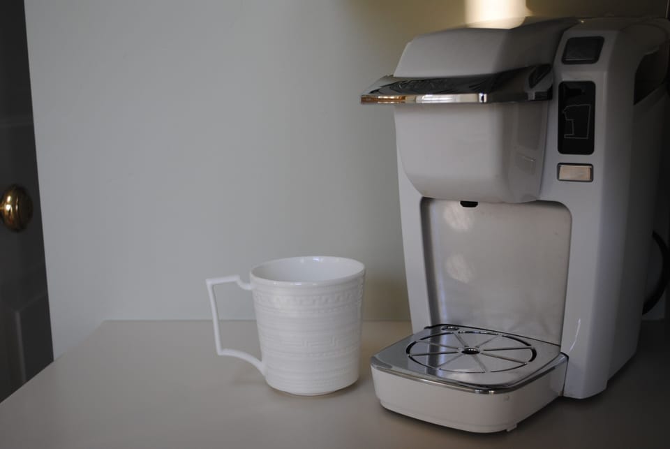 Mini kitchenette includes Keurig coffee pot, microwave, mini fridge, dishes etc.