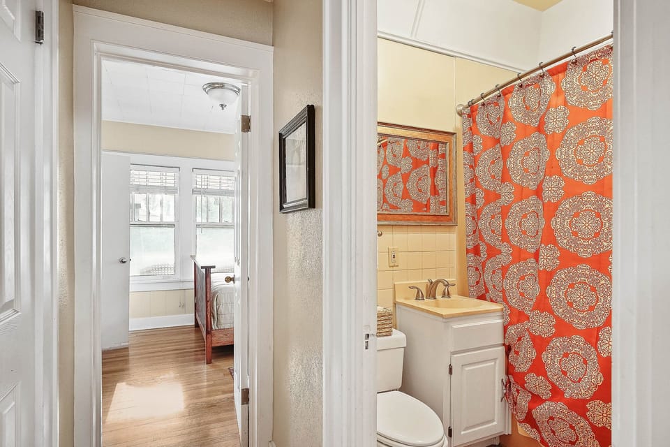 A small bath with whirlpool type tub located between the two main bedrooms. 