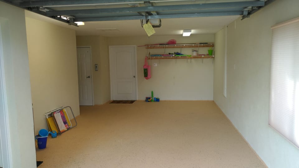Garage with door leading to bedroom and elevator