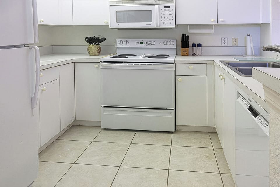 Bright, white, fully-equipped kitchen